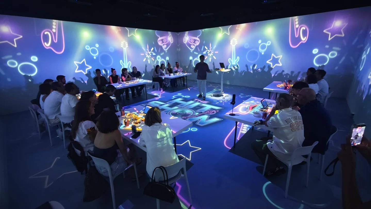 Equipos de Hit Show alrededor del escenario con proyecciones musicales en paredes y suelo